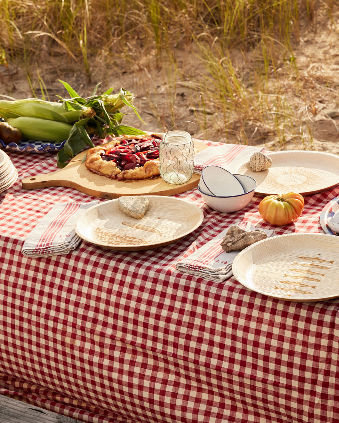 maaterra compostable palm leaf plates on a table at a beach.