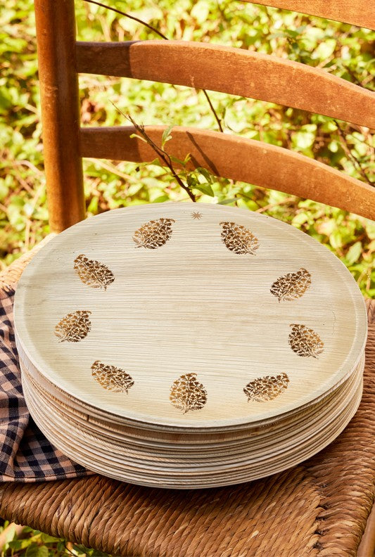 maaterra compostable palm leaf plate with block print wreath design on a chair outside