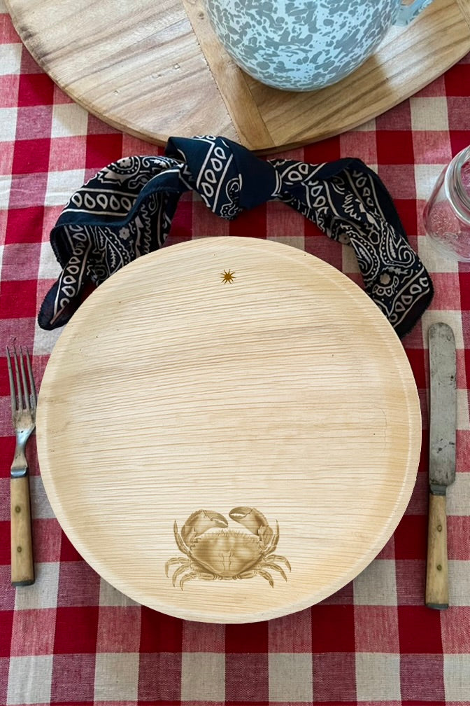 maaterra compostable palm leaf plate with crab design on a gingham tablecloth