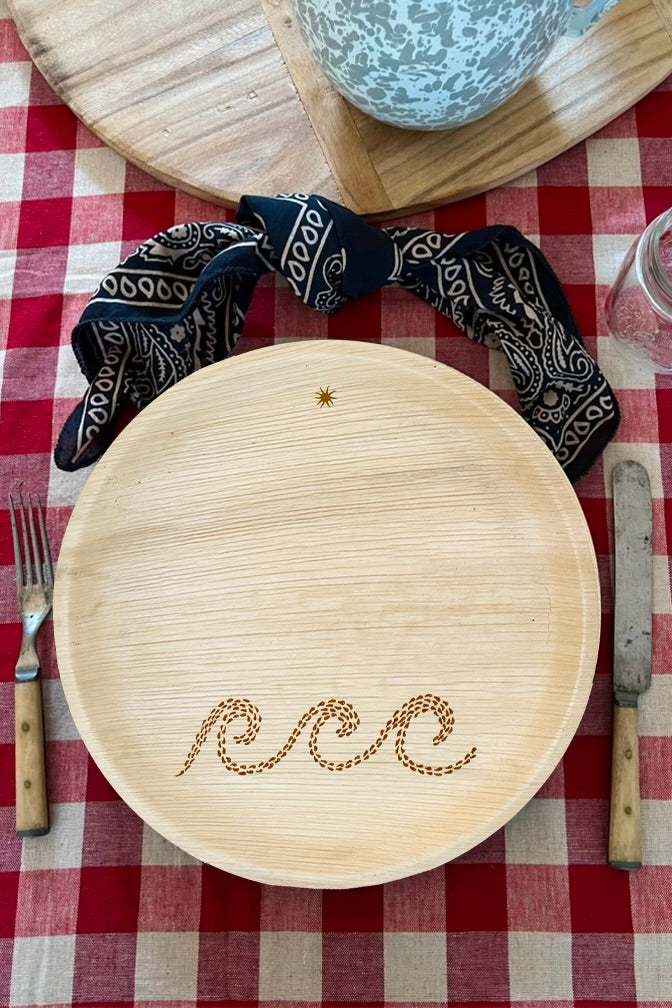 maaterra compostable palm leaf plate with waves design on a gingham tablecloth