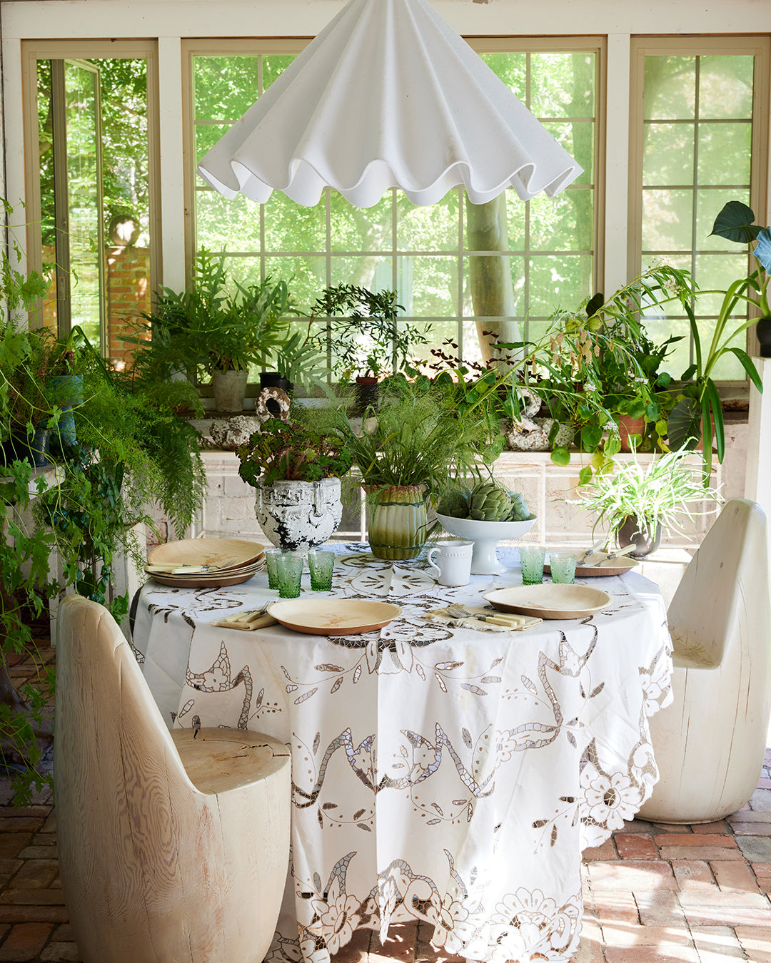 maaterra compostable palm leaf plates grace a table on beautiful enclosed porch.