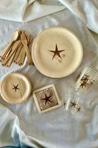 Wooden tableware set with star designs on a light fabric background