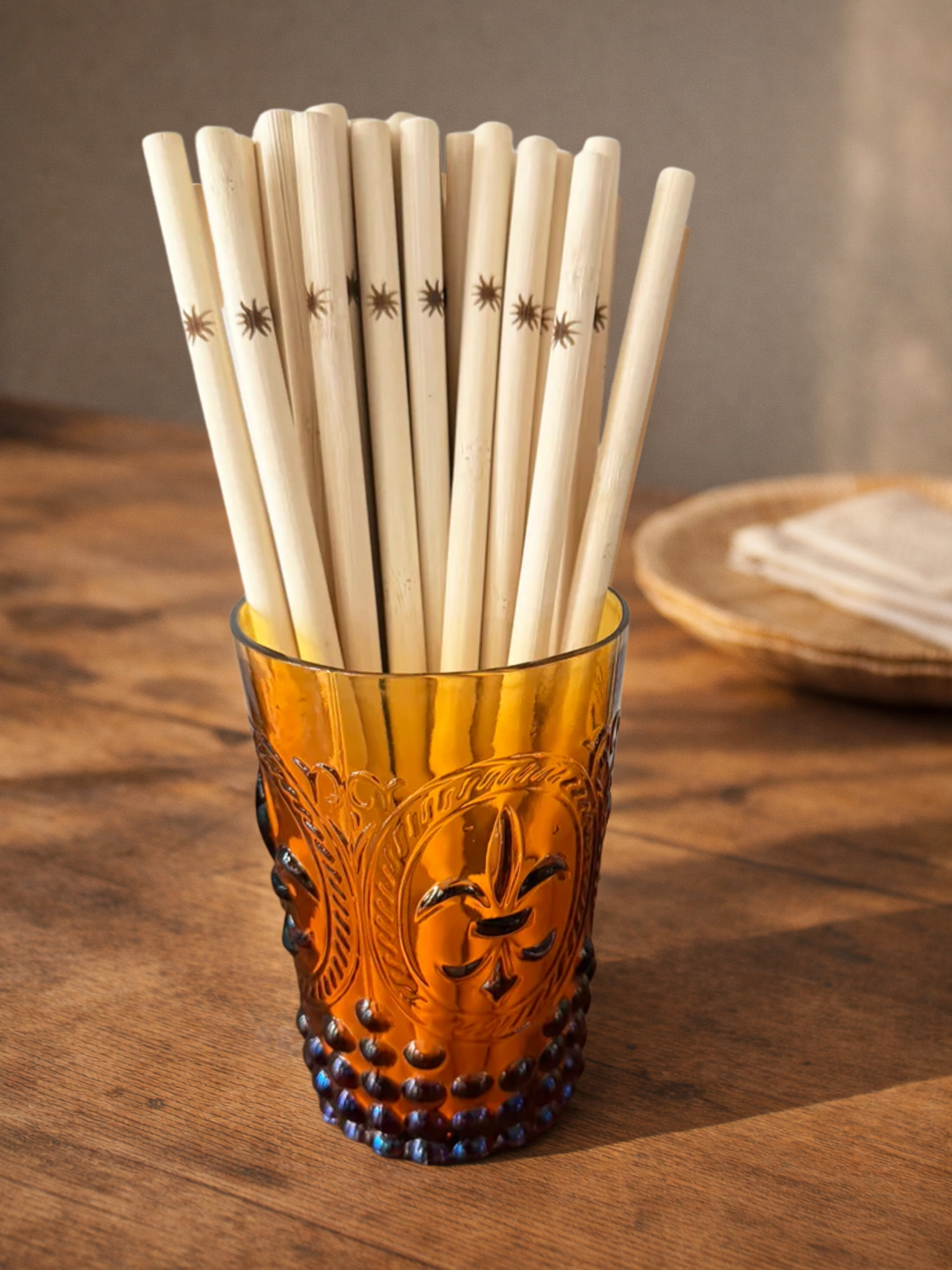 wooden and brown straws in a cup on a wooden surface