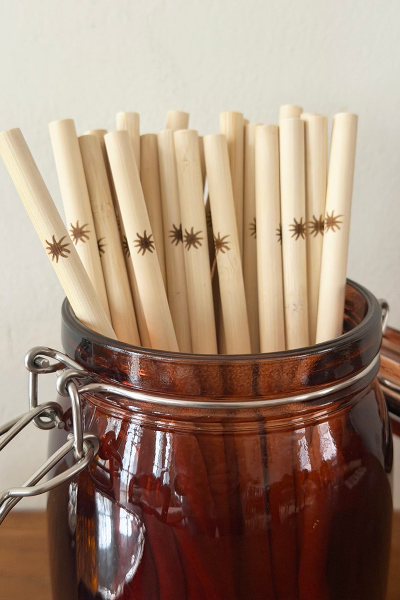 Jar filled with bamboo straws with star patterns on a neutral background