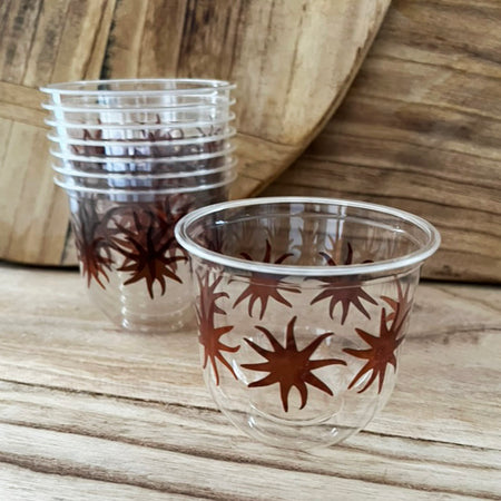 maaterra compostable cups with maaterra sun design on a wooden table