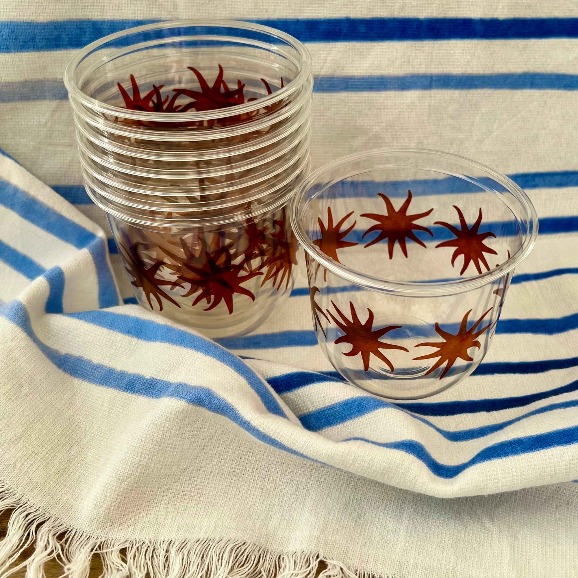 maaterra compostable cups with maaterra sun on a blue and white tablecloth