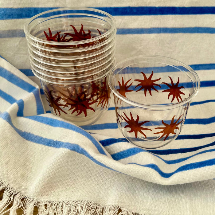 maaterra compostable cups with maaterra sun on a blue and white tablecloth