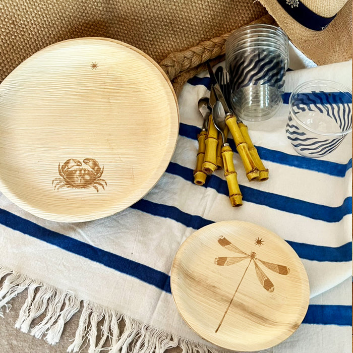 maaterra compostable palm leaf plate with crab design on a white background on a striped tablecloth