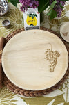 maaterra compostable palm leaf plate with grapes design on a woven charger