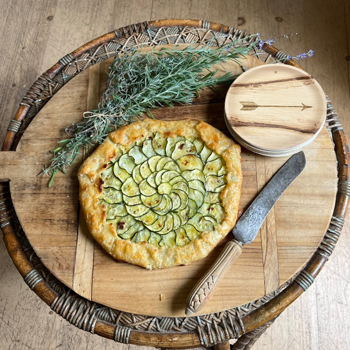 maaterra compostable palm leaf plate with single arrow design on a cutting board with zucchini tart