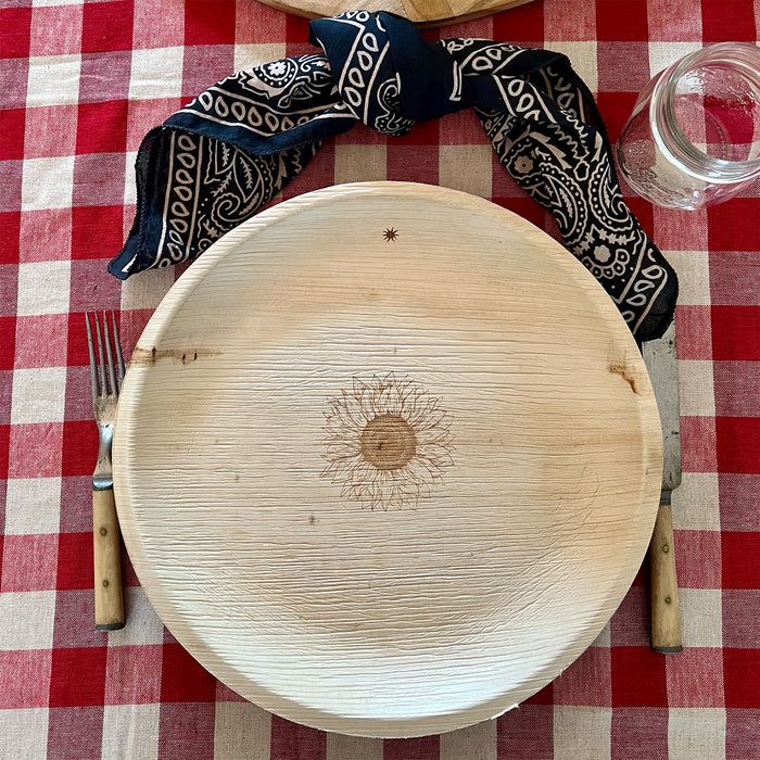 maaterra compostable palm leaf plate with sunflower design on a gingham tablecloth