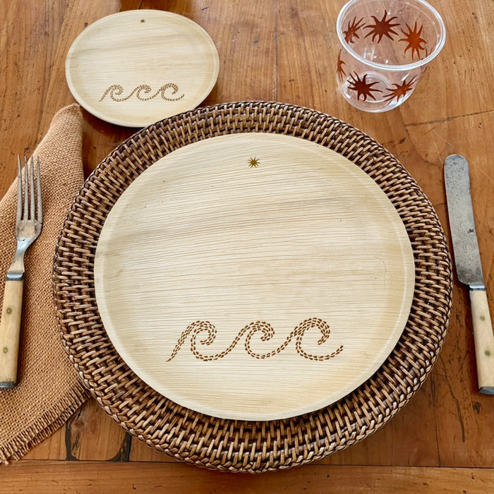 maaterra compostable palm leaf plate with waves design on a woven charger