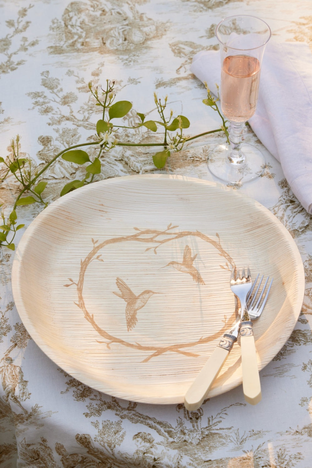 Wedding table set with maaterra compostable plate that has the hummingbird wreath design. 