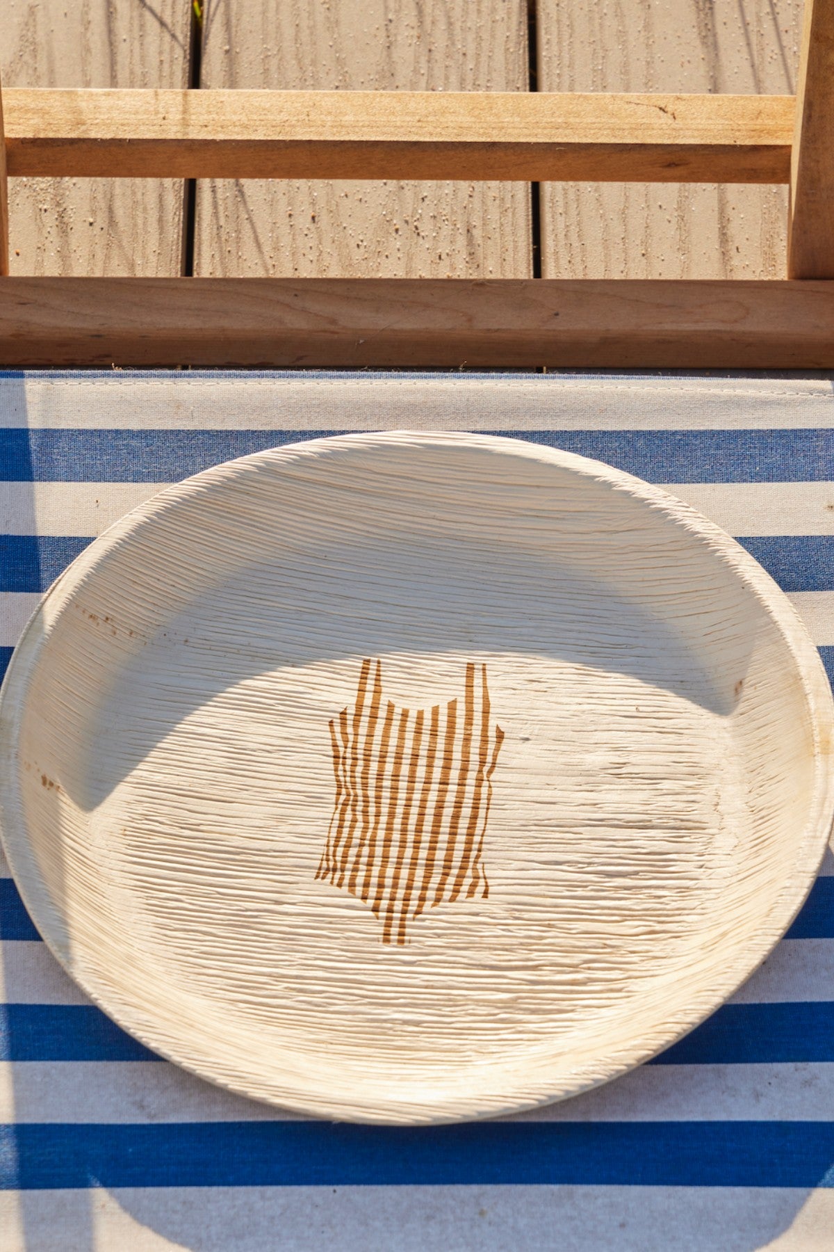 maaterra compostable palm leaf plate with  my-o, my-o, mailot design on a beach chair. 