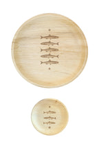 Palm leaf maaterra plate with stacked fish design on white background. 