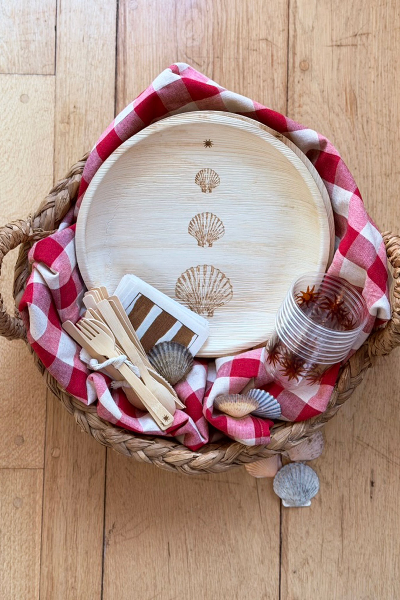 maaterra compostable palm leaf plate with stacked scallops design in a basket with other sustainable products. 