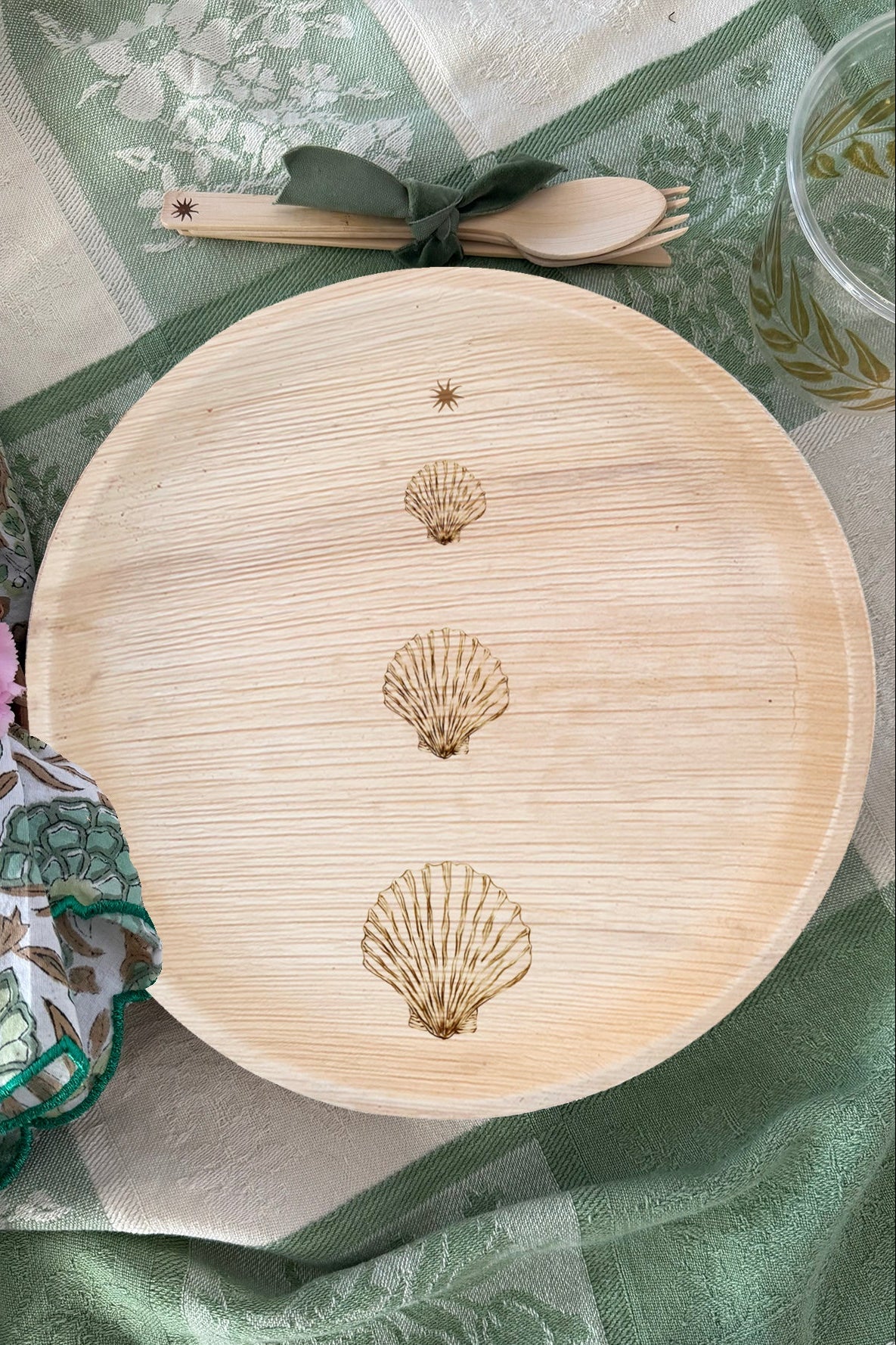 maaterra compostable palm leaf plate with stacked scallops design on a green and white background. 