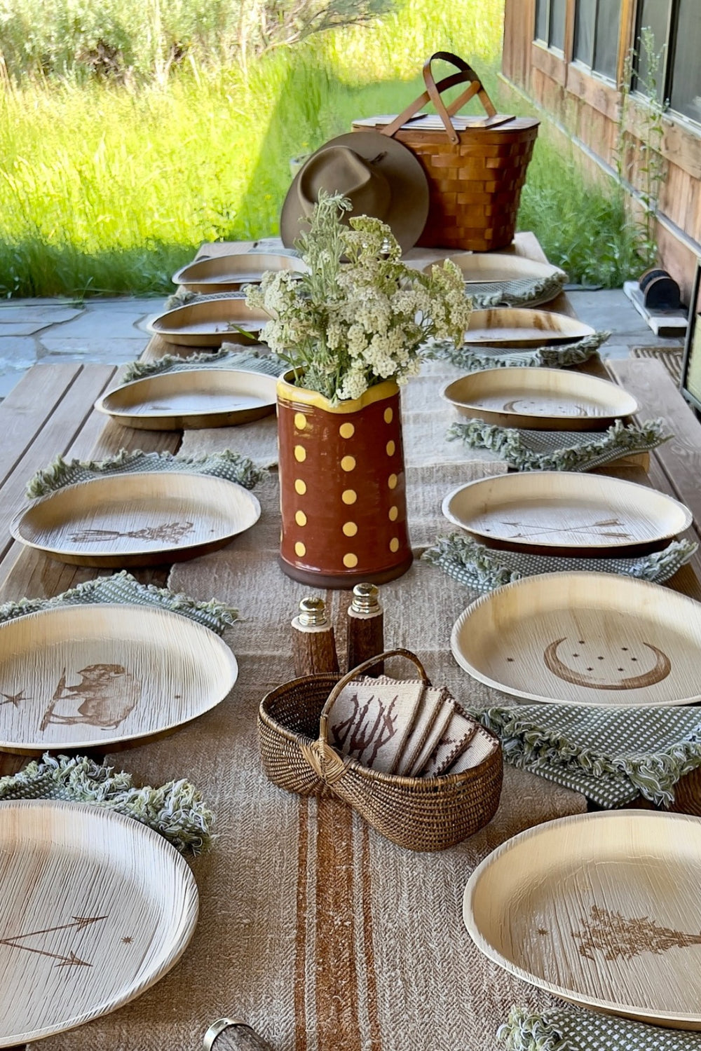 maaterra compostable plates with multiple engraved designs on a western themed table surrounded by grass. 